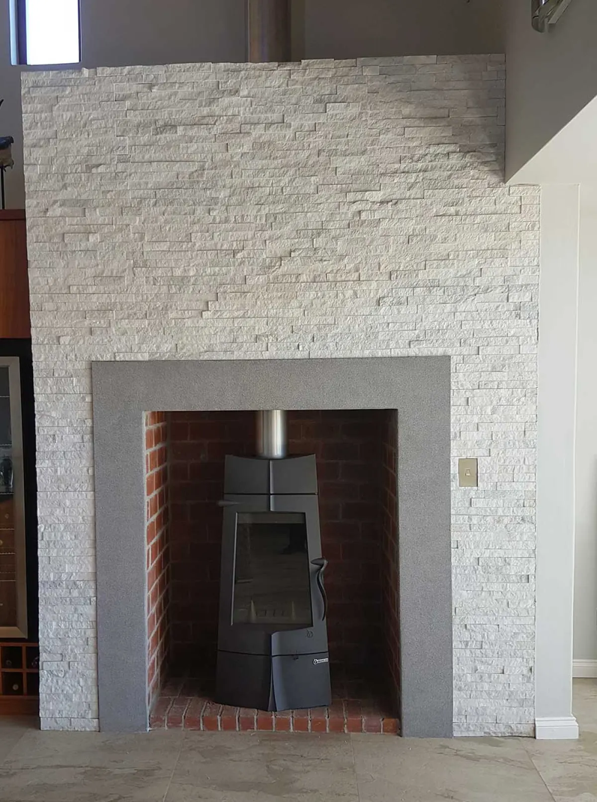 Restored brick firebox inside a stacked stone surround